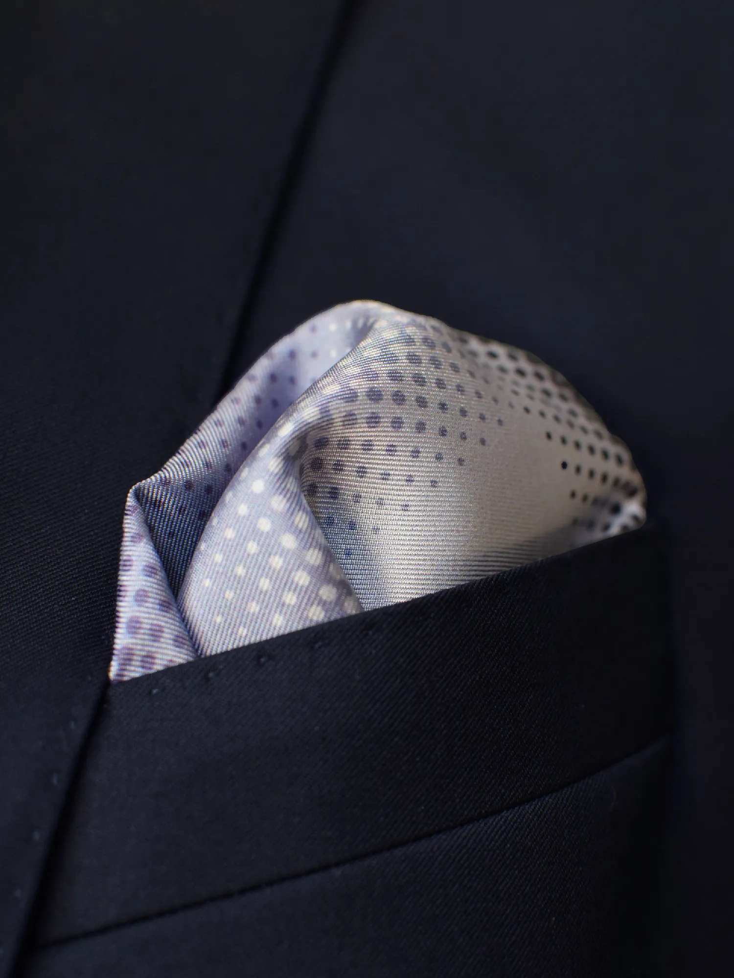 Pochette Lanvin portée dans veste noire, camaïeu violet avec détails subtils