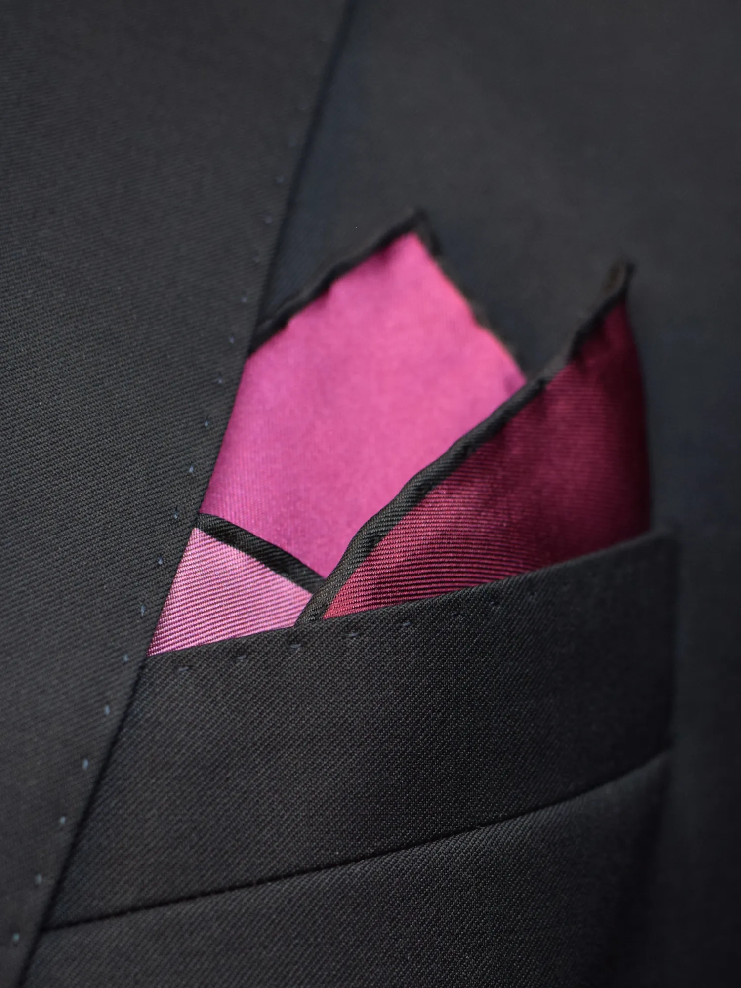 Pochette Lanvin pourpre pliée en pointe triple dans une poche de veste.