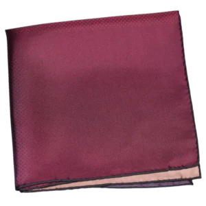 Pochette Lanvin pliée aux reflets pourpres et framboise, soulignée d’un liseré noir discret.