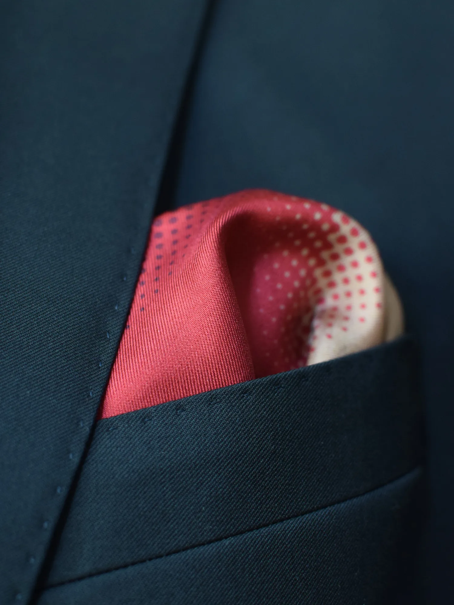 Pochette Lanvin en soie portée avec un pli bouffant, dévoilant les tons rouge vif et beige crème.