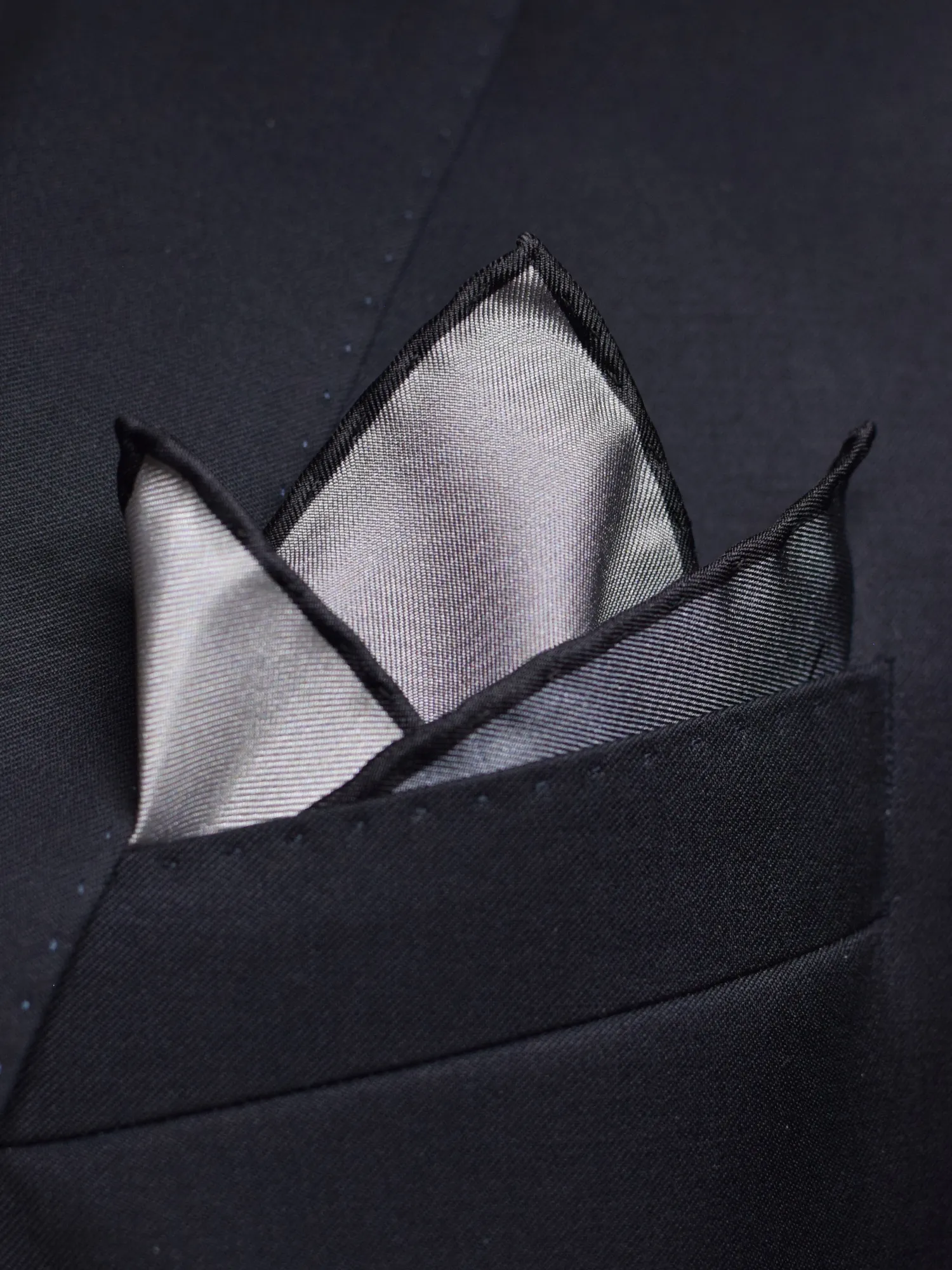 Pochette Lanvin gris dégradé pliée, détails du tissu et du logo visibles.