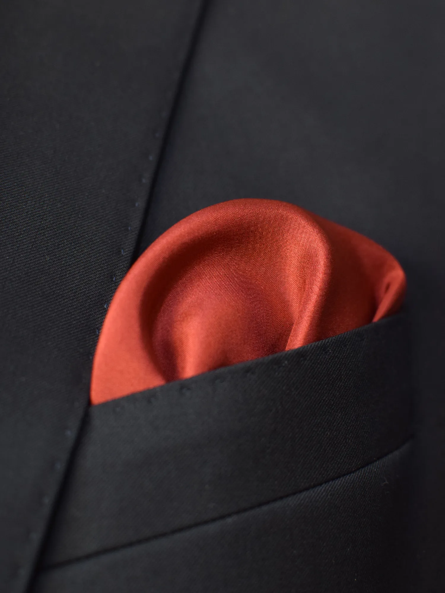 Pochette Lanvin en soie rouge, portée en costume, liseré contrastant bleu et marron.