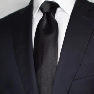 Cravate slim noire en soie portée sur chemise blanche