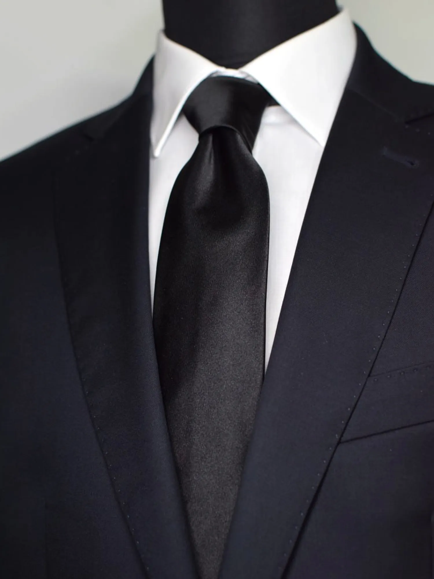 Cravate slim noire en soie portée sur chemise blanche